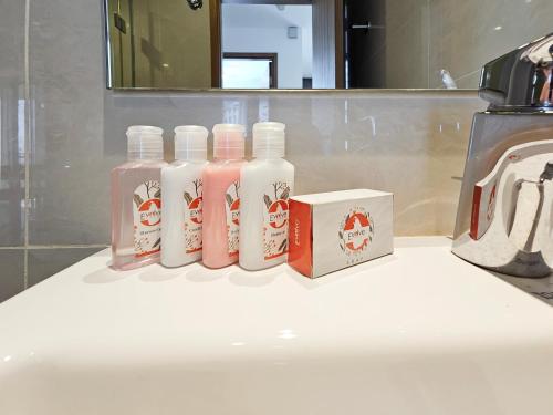 three bottles of soap and a box on a bathroom sink at Evolve - Céleste in Colombo