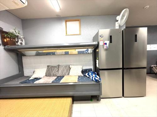 ein Schlafzimmer mit einem Etagenbett neben einem Kühlschrank in der Unterkunft Guest house cocode in Ishigaki-jima