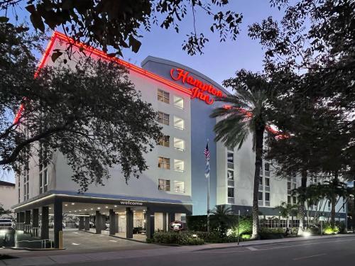 a hotel with a red sign on the front of it at Hampton Inn Miami-Coconut Grove/Coral Gables in Miami