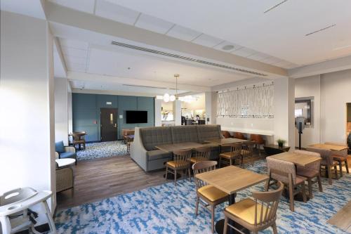 a lobby with a couch and tables and chairs at Hampton Inn Miami-Coconut Grove/Coral Gables in Miami