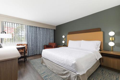 a hotel room with a large bed and a desk at Hampton Inn Miami-Coconut Grove/Coral Gables in Miami