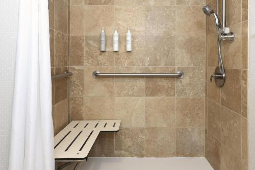 a shower with a bench and a shower curtain at Hampton Inn Miami-Coconut Grove/Coral Gables in Miami