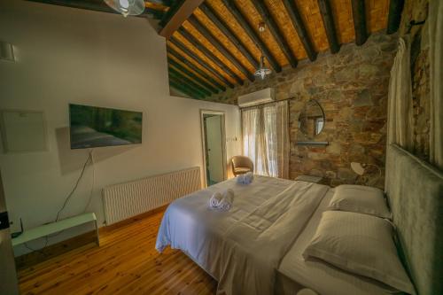 a bedroom with a large bed in a stone wall at Farmakas Living in Pharmakas