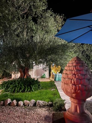 a pineapple statue in a garden with a tree at B&B Villa Mediterranea with private parking in Trani