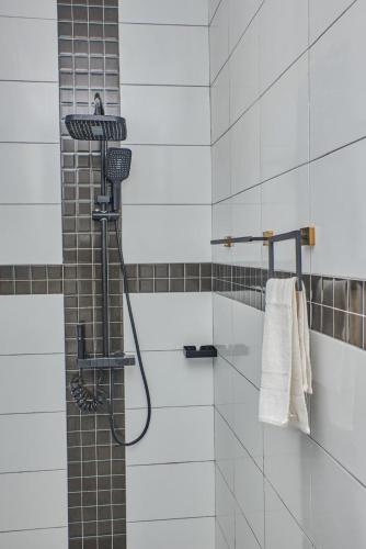 a shower with a hose in a bathroom at Diani Tulivu in Diani Beach