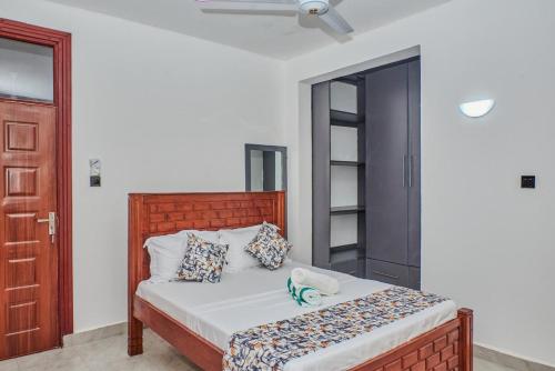 a bedroom with a bed with a wooden headboard at Diani Tulivu in Diani Beach