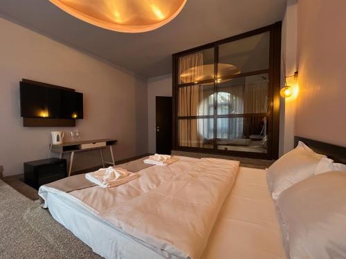a bedroom with a large bed and a television at Hotel Artimino in Timişoara