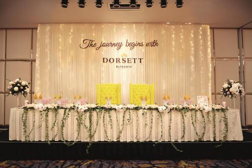 a table with flowers and a sign that reads the dancing keys club ddest at Dorsett Putrajaya in Putrajaya