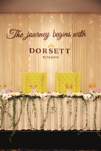 two yellow chairs behind a table with flowers at Dorsett Putrajaya in Putrajaya