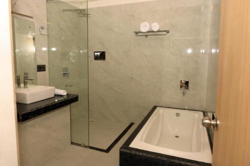 a bathroom with a glass shower and a sink at Hotel Grand Maspel in Dimapur