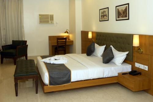 a hotel room with a large bed and a chair at Hotel Grand Maspel in Dimapur