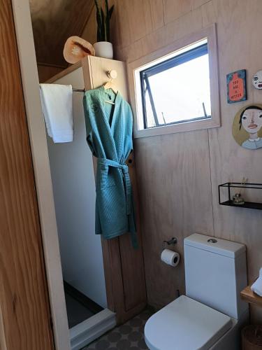 a small bathroom with a toilet and a window at The Round Tent Raglan in Raglan