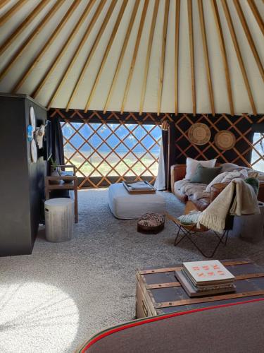 a living room with a yurt with a couch and a table at The Round Tent Raglan in Raglan