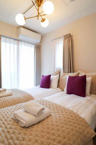 two beds sitting next to each other in a bedroom at Ken's Place Azabu-Juban in Tokyo