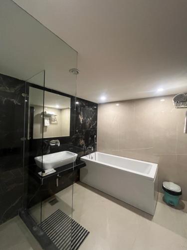 a bathroom with a bath tub and a sink at Paradise Resort Paonta in Pāonta Sāhib
