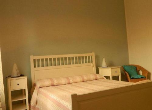 a bedroom with a bed with two night stands and a chair at Bed And Roses in Montesilvano