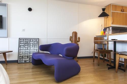 une chaise bleue dans une chambre avec une table dans l'établissement Cité Radieuse - Le Corbusier, à Marseille