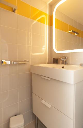 une salle de bain avec un lavabo et un miroir dans l'établissement Cité Radieuse - Le Corbusier, à Marseille