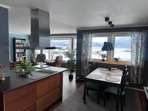 a kitchen with a table and a dining room at Home with a view in Storholmen