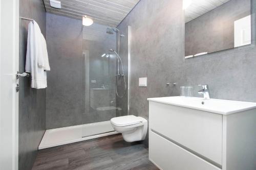 y baño con aseo, lavabo y ducha. en Arnarstapi Cottages en Stapi