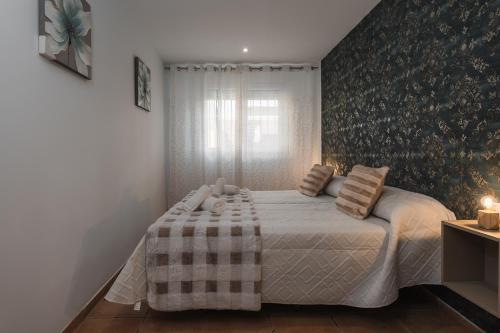 a bedroom with a bed with a blanket and pillows at Casa del sol Armilla in Armilla