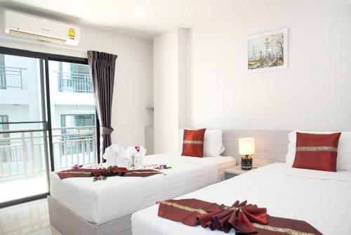 two beds in a room with a balcony at Aurora Suvarnabhumi in Bang Hia