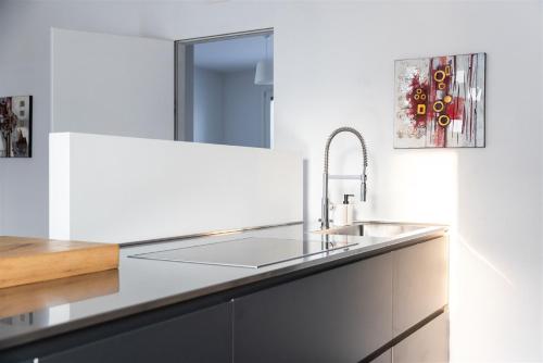 a white kitchen with a sink and a mirror at IseoLakeRental - Villa Edwige in Provaglio d'Iseo