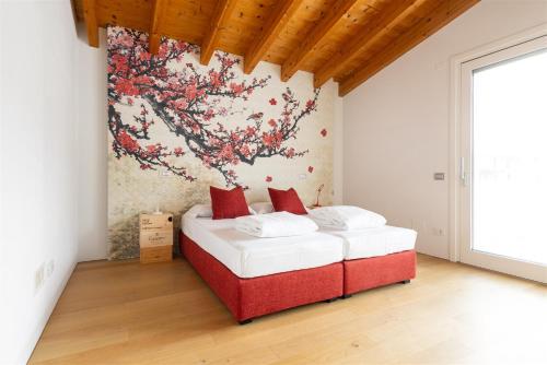 a bedroom with a red and white bed with a painting on the wall at IseoLakeRental - Villa Edwige in Provaglio d'Iseo