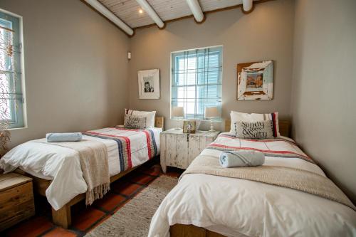 a bedroom with two beds and a window at Lekkerlag in Paternoster