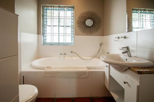 a bathroom with a tub and a sink and a toilet at Lekkerlag in Paternoster