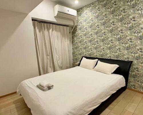 a bedroom with a large white bed with a heater at 青葉邸 AOZORA 1002 Near Dotonbori 3LDK 2 Bath 2 WC Premium Tower Residence in Osaka