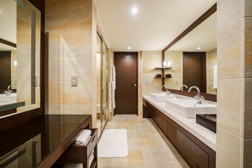 a bathroom with two sinks and two mirrors at Hyatt Regency Hakone Resort and Spa in Hakone