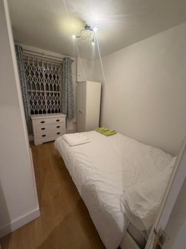 a bedroom with a white bed and a refrigerator at Central London 2 bedroom apartment by the river thames in Victoria zone 1 in London