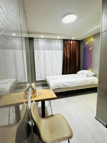 ein Schlafzimmer mit einem Bett, einem Tisch und einem Stuhl in der Unterkunft Emoji Hotel in Ongon
