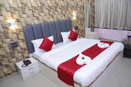 a bedroom with a large bed with red and white pillows at Hotel White House in Navi Mumbai