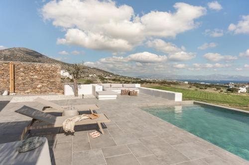 a villa with a swimming pool and a patio at Lolantonis - 3BR Sea View & Infinity Pool - Thymari in Aspro Chorio Paros