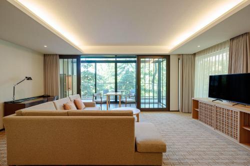 a living room with a couch and a television at Hyatt Regency Hakone Resort and Spa in Hakone