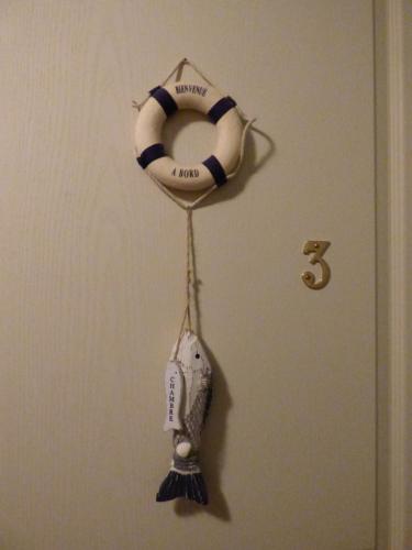 a towel hanging on a door with a life preserver at La Ferme du Manoir Etretat in Bordeaux-Saint-Clair