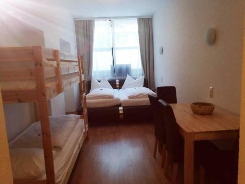 a room with two bunk beds and a table at Econnomy Adler in Golling an der Salzach