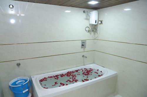 a bath tub filled with red flowers in a room at Hotel White House in Navi Mumbai