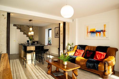 a living room and kitchen with a couch and a table at Parenthèse Enchantée – Proche Disney in Collégien