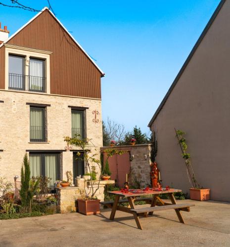a wooden picnic table in front of a building at Parenthèse Enchantée – Proche Disney in Collégien
