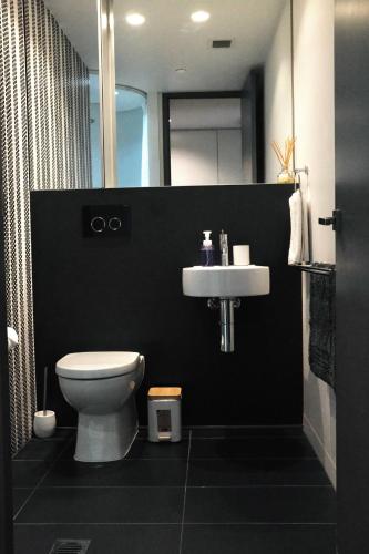 a bathroom with a white toilet and a sink at Chapel Street Hideaway in Melbourne