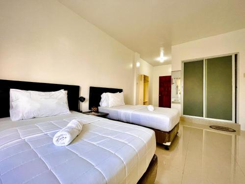 a hotel room with two beds and a bathroom at Arriyus Apartelle in Maya