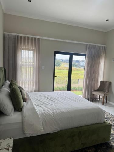 a bedroom with a large bed and a large window at Eye with a view in Eikenhof