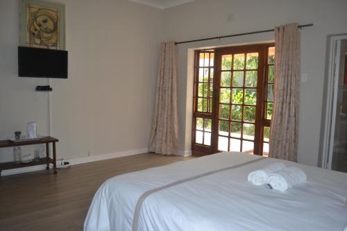 Un pat sau paturi într-o cameră la Cycad Lodge