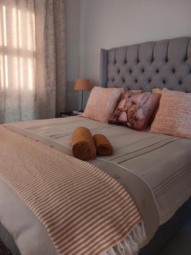 a large bed with two brown towels on it at the Host at Bingos House Self Catering in Thohoyandou