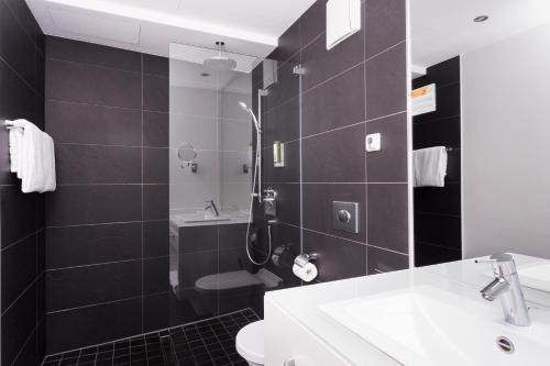 a bathroom with a shower and a toilet and a sink at Grimm's Berlin Mitte in Berlin