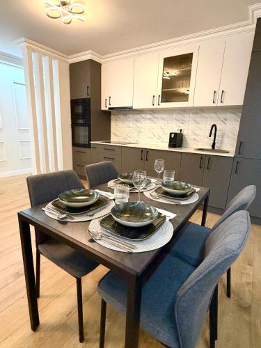 a wooden table with plates and glasses on it in a kitchen at Acasa Concept in Arad