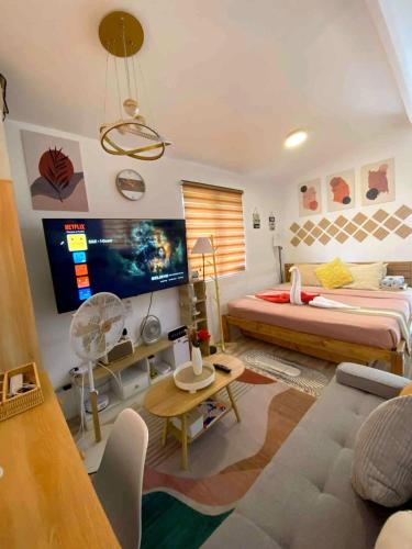 a bedroom with a bed and a couch and a tv at Olango Island - S&E-2 Tiny Guest House Fully Furnished with Hot Shower, Washer, Wi-Fi, Netflix & King-size Bed in Lapu Lapu City